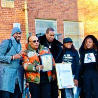 NYC Public Advocate Jumaane Williams, William “Spliff Star” Lewis, (Busta Rhymes) Trevor George Smith, Jr. holding a Proclamation from PA Williams, Assembly Member Monique Chandler Waterman, and Dr. Meda Leacock, after a turkey donation by the Grammy-nominated rapper at PS 35 in Brooklyn where he attended school.