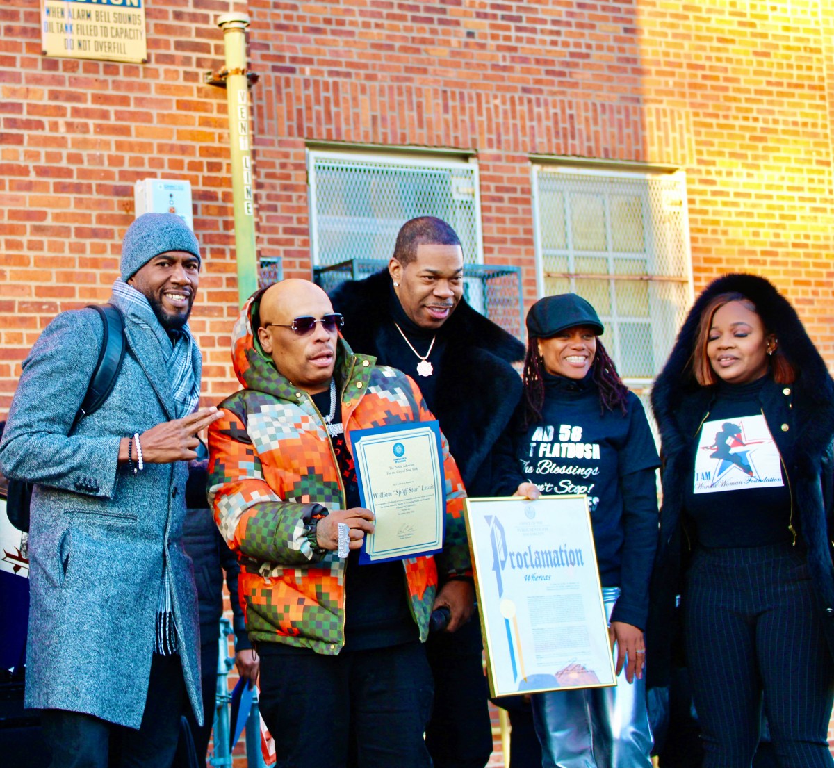 NYC Public Advocate Jumaane Williams, William “Spliff Star” Lewis, (Busta Rhymes) Trevor George Smith, Jr. holding a Proclamation from PA Williams, Assembly Member Monique Chandler Waterman, and Dr. Meda Leacock, after a turkey donation by the Grammy-nominated rapper at PS 35 in Brooklyn where he attended school.