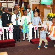 Sunday School children perform while Assistant Superintendent Joycelyn King, far right, sitting, guides them.