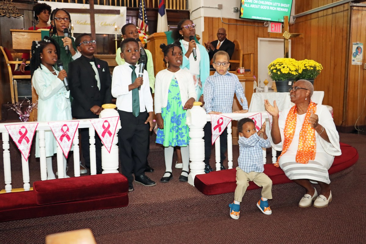 Sunday School children perform while Assistant Superintendent Joycelyn King, far right, sitting, guides them.