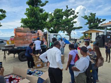 Assembly Member Jaime Williams, left, and her delegation delivering supplies to residents at a shelter on Carriacou.