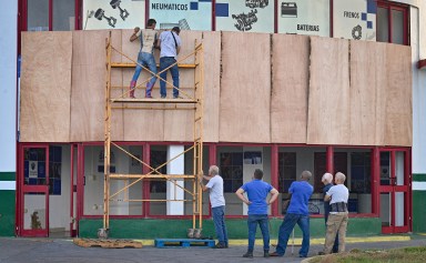 Workers protect a facility ahead of the arrival of tropical storm Rafael in Havana on November 5, 2024. Cuba was bracing for Tropical Storm Rafael, which is expected to make landfall on the island as a hurricane on Nov. 6, compounding the misery wrought by a massive blackout and Hurricane Oscar.