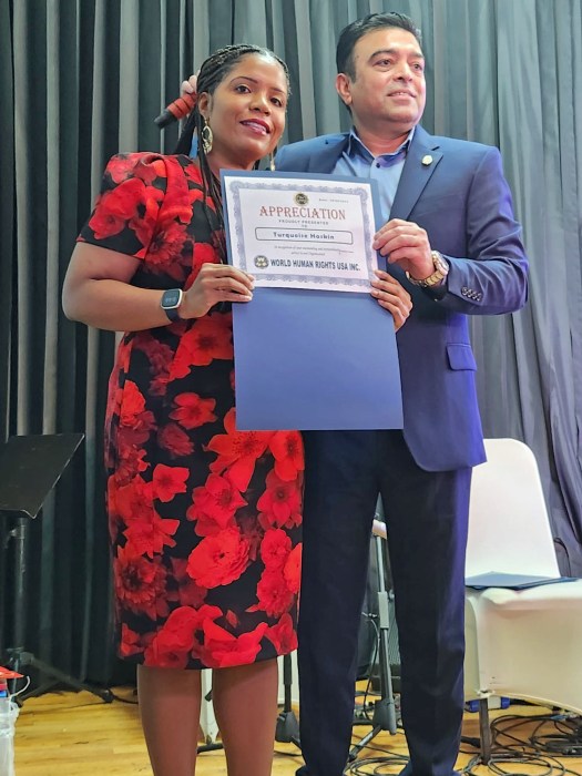 Turquoise Haskin Esq. candidate for Civil Court Judge, Kings County, Brooklyn, being presented with a Certificate of Appreciation from the organizer Saghir Khan at the WHRUSA 2024 2nd Convention and Cultural Show at Queens Palace in Woodside on Oct. 19.