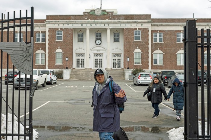 Recently arrived migrants walk to a bus stop outside Floyd Bennett Field shelter on February 21, 2024 in the Brooklyn borough of New York.