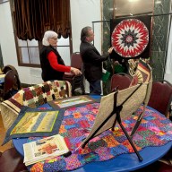 Senator Addabbo admires Louise Naples’ handmade quilts.