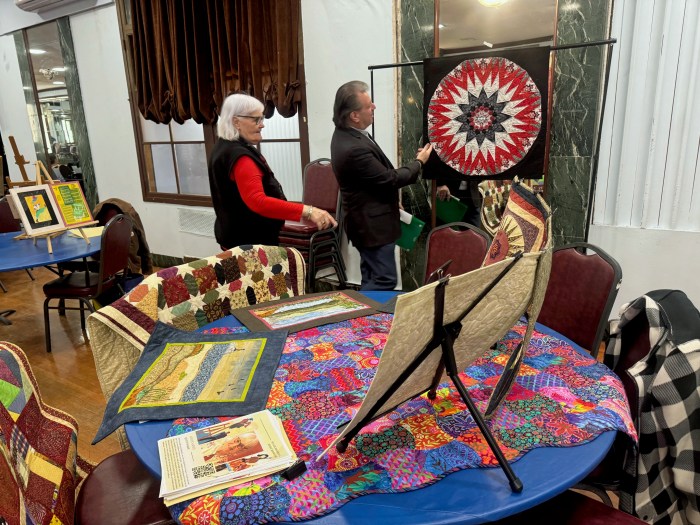 Senator Addabbo admires Louise Naples’ handmade quilts.