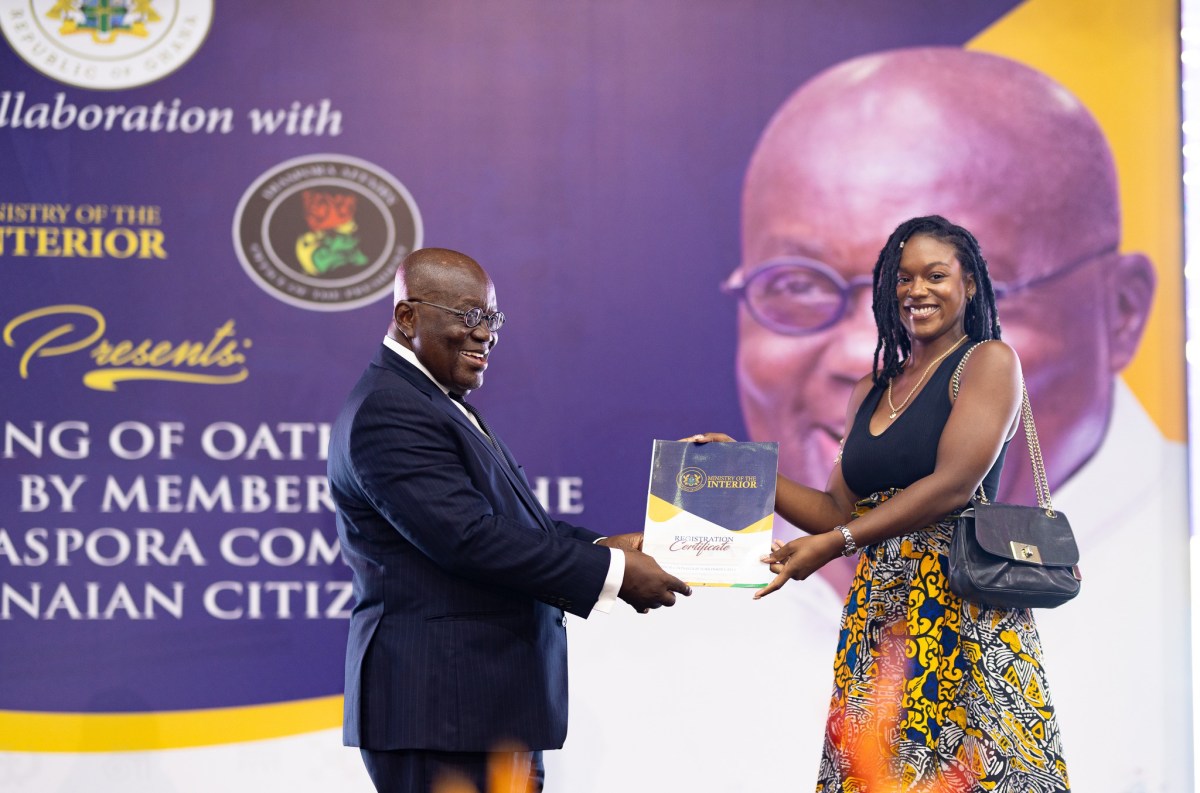 Jamaican Canadian Keondra Tomlinson-Gayle, right, is being presented with her certificate of Ghanaian citizenship by President President Akufo-Addo after being sworn in among more than 200 Afro-Caribbean citizens at a ceremony on Nov. 19, 2024, in Accra, Ghana.