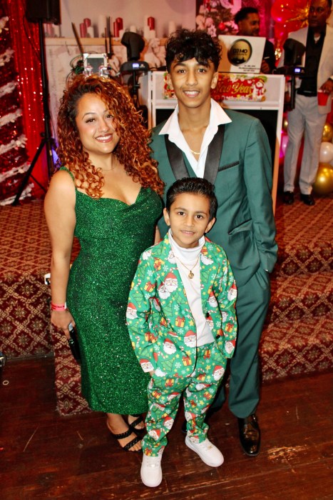 Up-and-coming Broadway singer Brian Chan, right, who sang a ballot at the Annual Guyanese Essequibians Organization of America Christmas party last Saturday at Liberty Palace, is pictured with his lovely family.