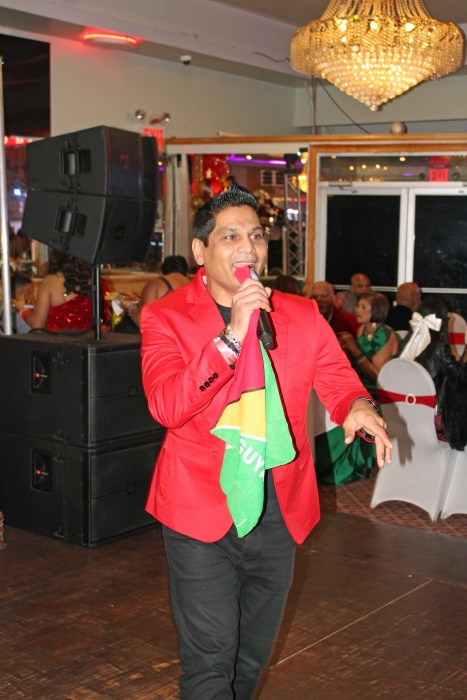 Hotshot performer Pally Dass showcases the Golden Arrowhead Guyana flag as he sings Guyana Baboo, a hit song made popular by Chutney singer Terry Gagraj. He entertained a large crowd at Liberty Palace in Richmond Hill during the Annual Guyanese Essequibians Organization of America Annual Christmas party on Saturday, Dec. 7.