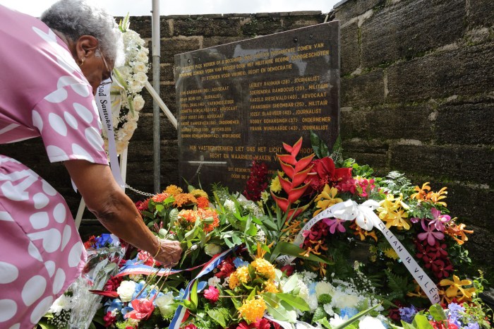 Relatives of victims of the December murders, when 15 victims were executed on Dec. 8, 1982 at the former military barracks of Fort Zeelandia, lay flowers at a monument during the 40th anniversary of the event in Paramaribo, on Dec. 8, 2022. - Former President Desi Bouterse was sentenced in August 2021 to 20 years jail time by the Suriname Court Martial for the executions when he was the country's military ruler and is now in the middle of his appeals case. 