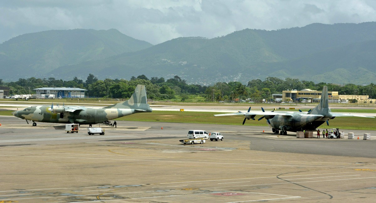 Workers at Piarco international Airport, Trinidad, load a Venezuelan military plane with food products on June 23, 2016, in the first airlift of goods to be taken to Sucre state, Venezuela, aimed at bringing relief to a critical food shortage in that country