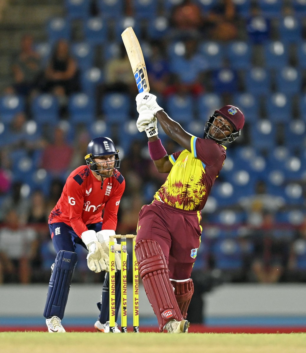 Sherfane Rutherford of the West Indies hits out for six runs watched by England wicketkeeper Phil Salt during the 4th T20 International between the West Indies and England at Daren Sammy National Cricket Stadium on Nov. 16, 2024 in Gros Islet, Saint Lucia.