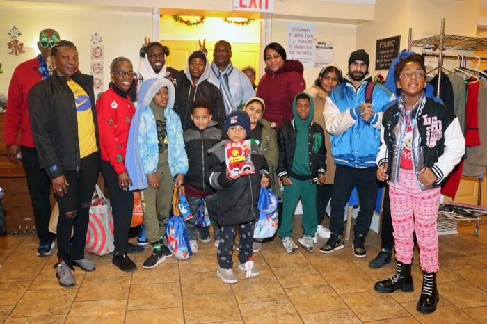 Pastor the Rev. Roger Jackson, in red shirt, back row, left, partly hidden, with Marlen Ferguson, second from left, front row, with families and coordinators of the Staten Island Family Transition Center.