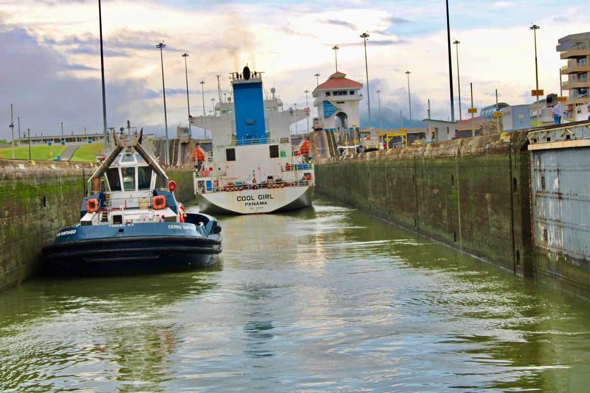 A cargo ship is seen passing through the Panama Canal, a historic passageway that accommodates thousands over many years.