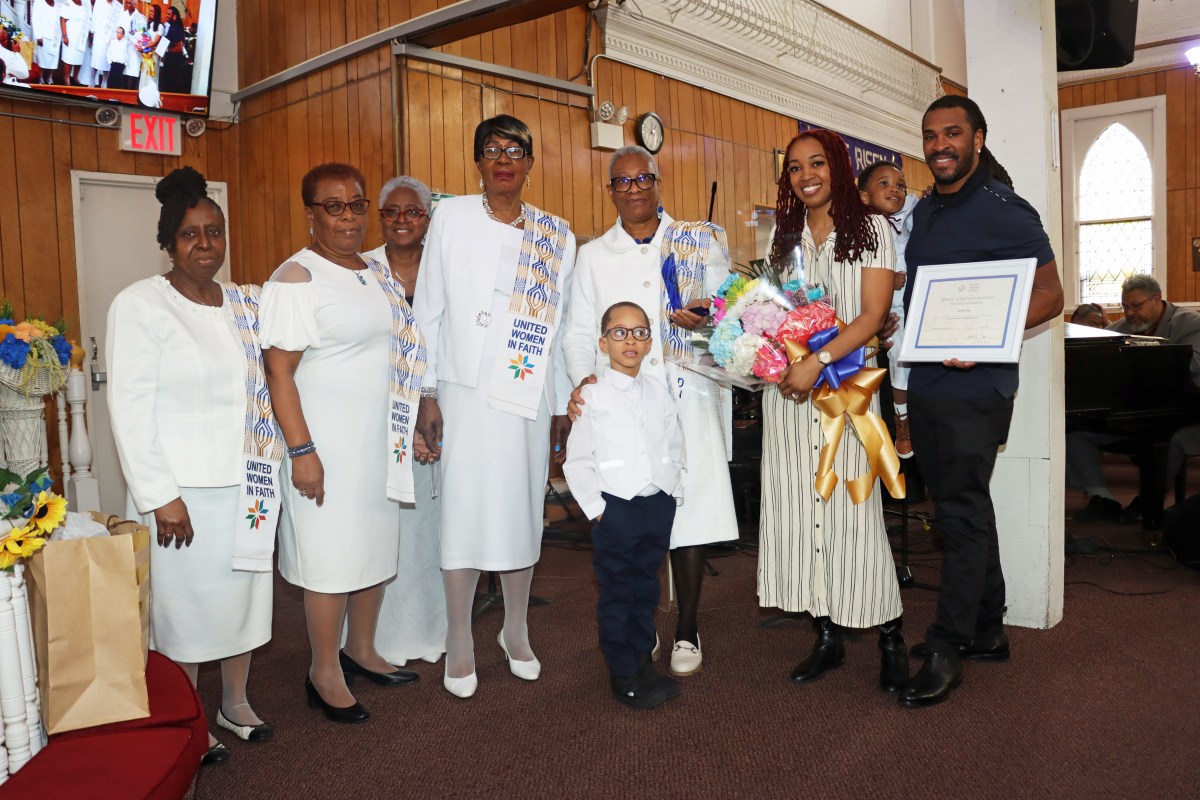 Sis. Joycelyn King, third from right, with grandson Chase King; son, Charles King, holding certificate; his wife, with bouquet of flowers; and members of Fenimore Street United Women of Faith's Special Mission Recognition Committee.