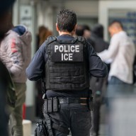 An ICE agent monitors hundreds of asylum seekers being processed upon entering the Jacob K. Javits Federal Building on June 6, 2023 in New York City.