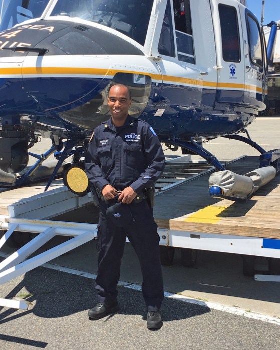 Detective Charles stands beside an NYPD air-sea rescue helicopter used for water rescues and medical evacuations.