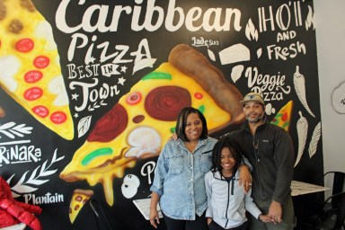 From left, Trinidad native Natalie Lamming, and Grenadian native Davis Alexander, pose with 11-year old Sebastian, owner of Spices & Slices at 1828 Nostrand Ave., Brooklyn, a Caribbean style pizzeria.